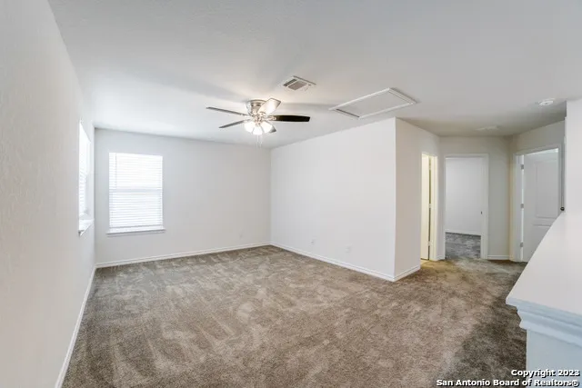 a view of an empty room with a ceiling fan