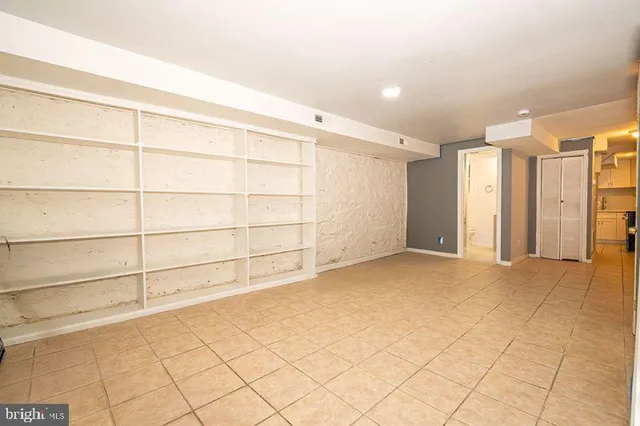 a view of a hallway with wooden shelves