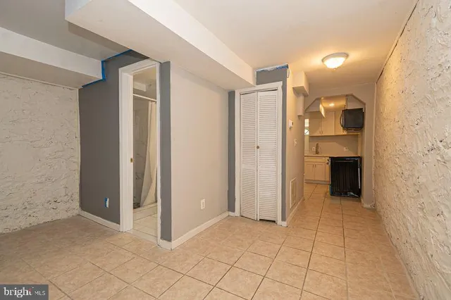 a view of a refrigerator in kitchen and white cabinets