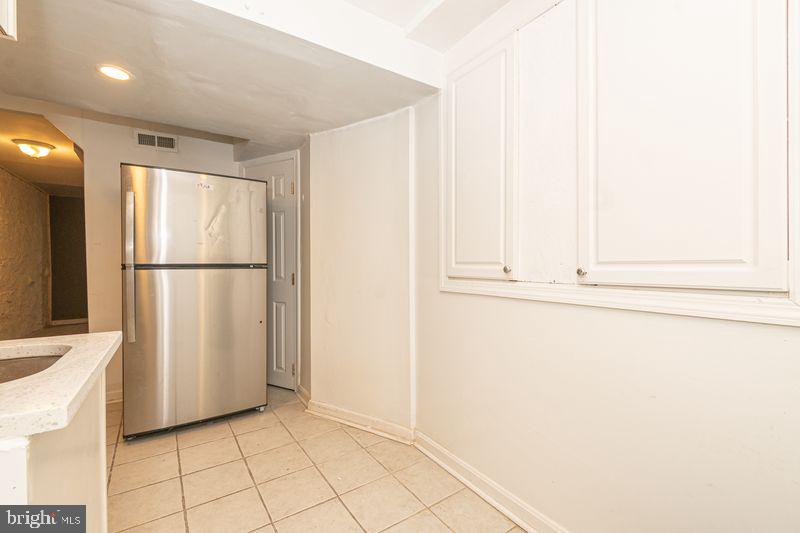307 East 25th Street, Unit BASEMENT APARTMENT Baltimore, MD 21218 - Photo 13 of 21 a view of a refrigerator in kitchen and white cabinets