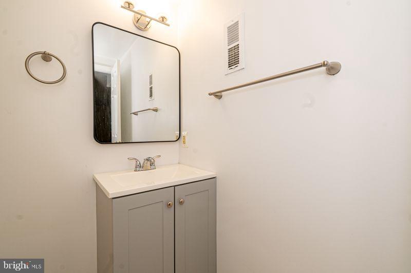 307 East 25th Street, Unit BASEMENT APARTMENT Baltimore, MD 21218 - Photo 8 of 21 a bathroom with a mirror sink and vanity