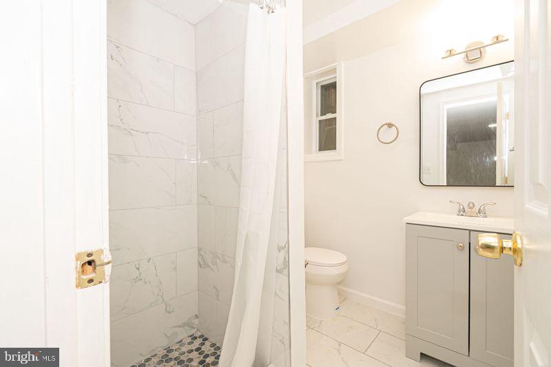 307 East 25th Street, Unit BASEMENT APARTMENT Baltimore, MD 21218 - Photo 9 of 21 a bathroom with a toilet sink and a mirror