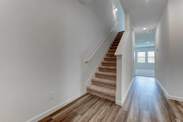 a view of a hallway with wooden floor and entryway