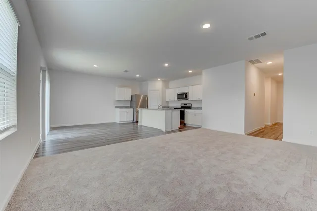 a view of large kitchen with a refrigerator oven a counter top space and cabinets