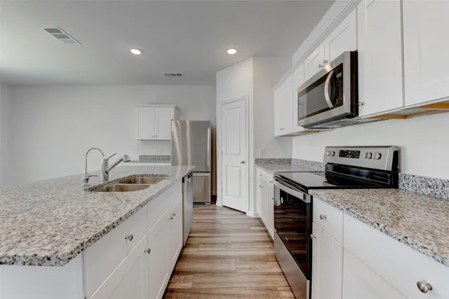 a kitchen with stainless steel appliances granite countertop a sink stove and refrigerator