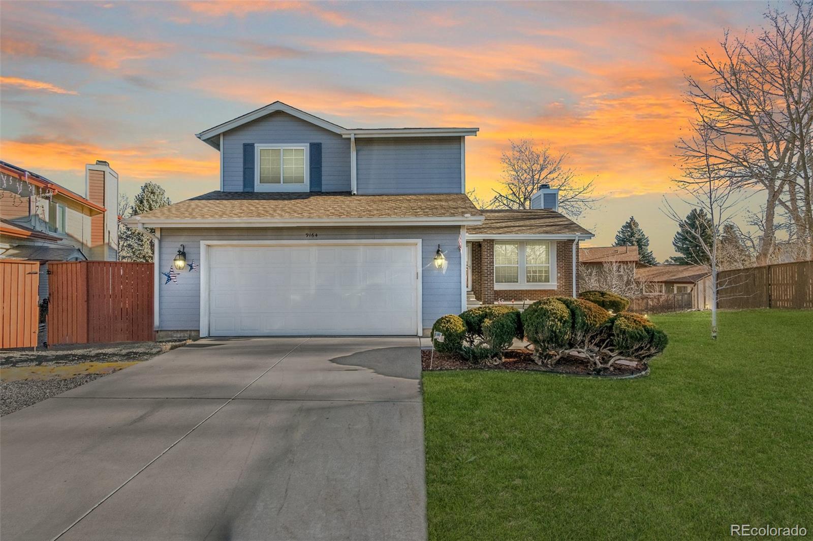 9164 Bitterweed Court Highlands Ranch, CO 80126 - Photo 1 of 27 a front view of a house with a garden and plants