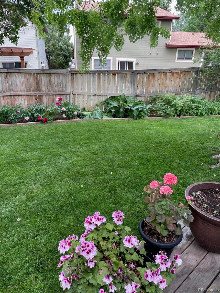 9164 Bitterweed Court Highlands Ranch, CO 80126 - Photo 23 of 27 a garden with flowers and wooden fence