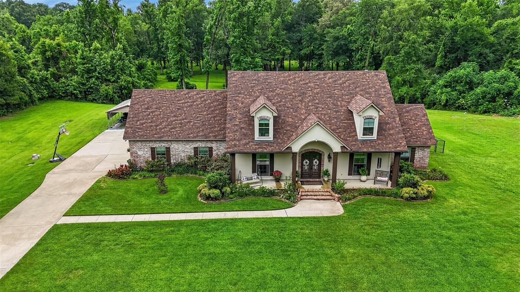 Stone and stucco exterior featuring dormer windows and a covered front porch