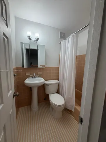 a bathroom with a sink toilet a mirror and shower