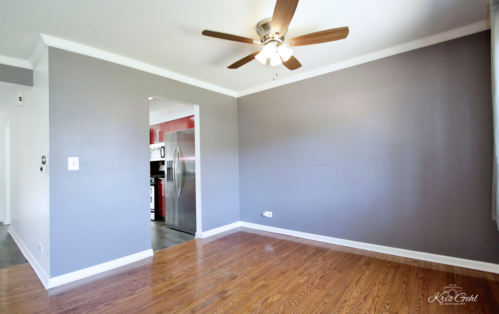 416 Arrow Trail, Unit 416 Wheeling, IL 60090 - Photo 5 of 24 an empty room with wooden floor and a ceiling fan
