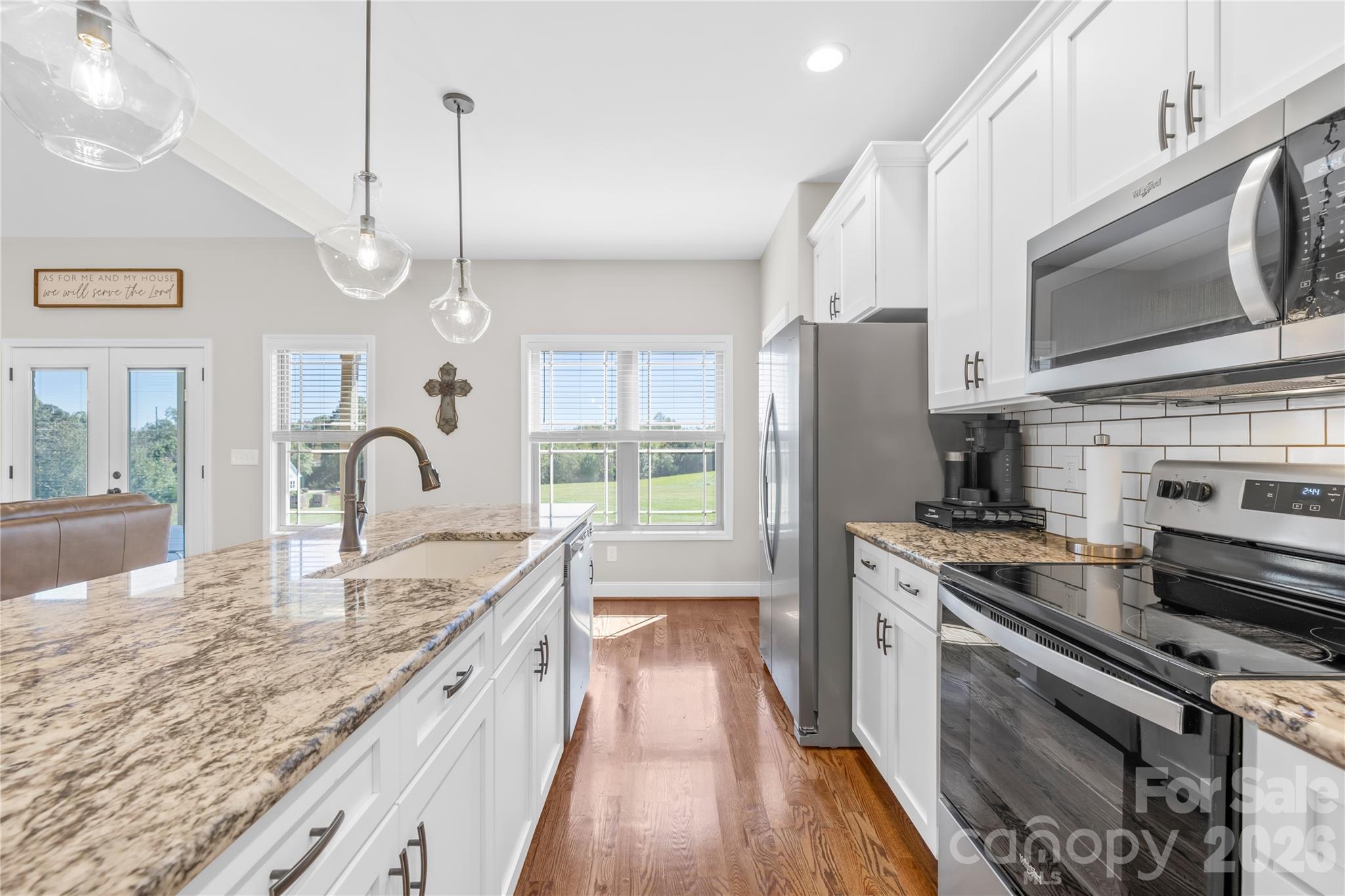 895 Oak Ridge Farms Circle Newton, NC 28658 - Photo 25 of 43 a large kitchen with granite countertop a stove a sink dishwasher a refrigerator and a fireplace with wooden floor