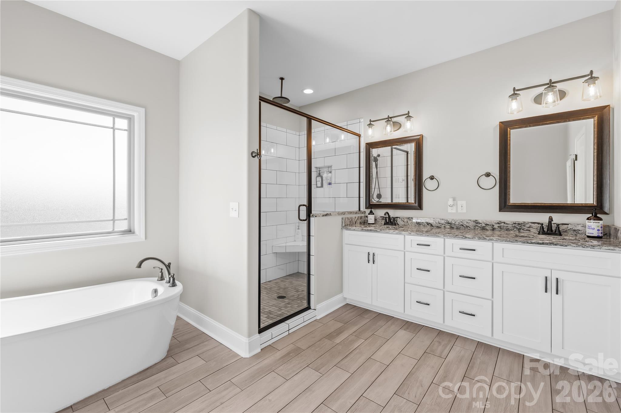 895 Oak Ridge Farms Circle Newton, NC 28658 - Photo 30 of 43 a spacious bathroom with double vanity a mirror and a bathtub