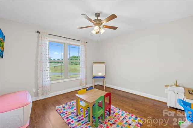a work space with wooden floor and a chandelier fan