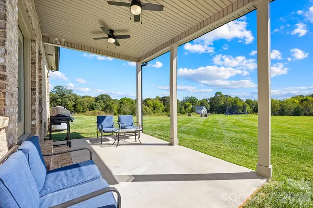 a view of a patio with a table chairs and backyard