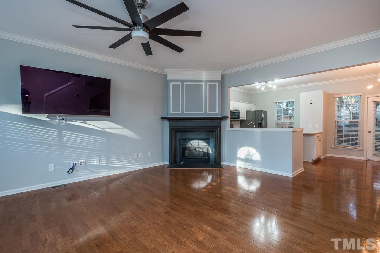 7244 Janston Drive Raleigh, NC 27613 - Photo 3 of 19 a view of a livingroom with a fireplace a ceiling fan and wooden floor