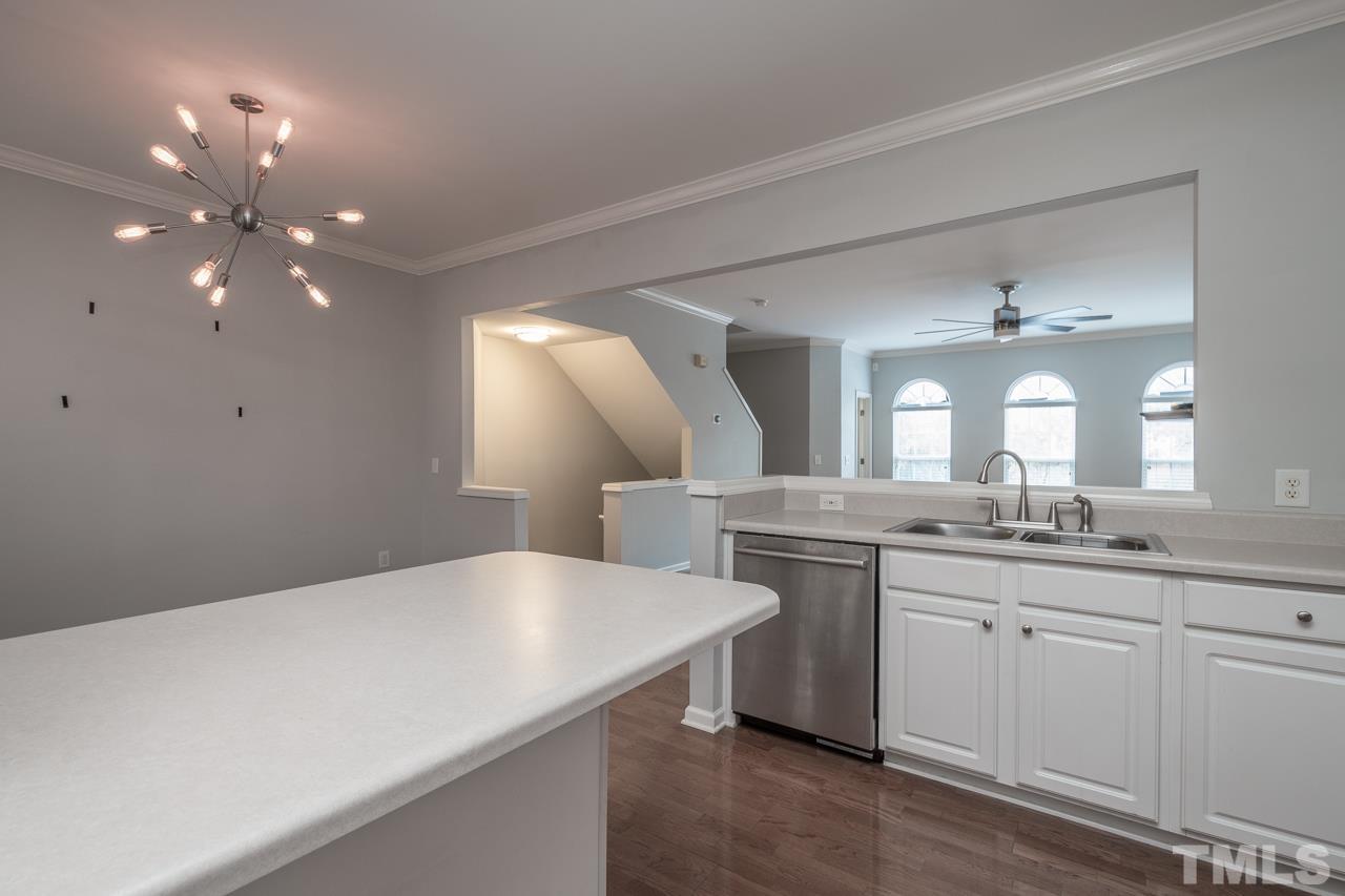 7244 Janston Drive Raleigh, NC 27613 - Photo 6 of 19 a kitchen with center island and chandelier