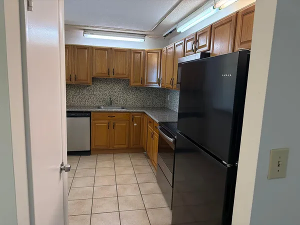a kitchen with stainless steel appliances granite countertop a refrigerator and a sink