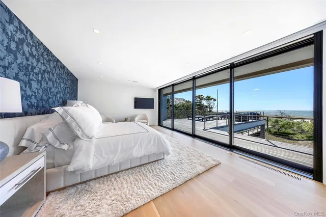a large bedroom with a bed and wooden floor