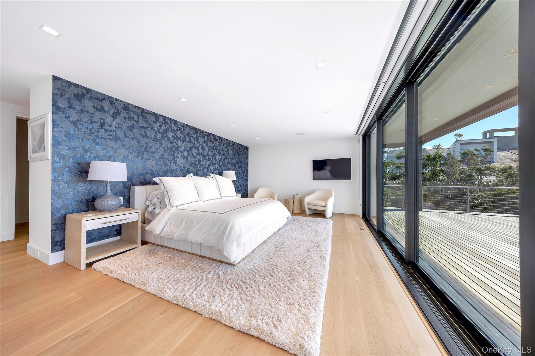 345 Dune Road Westhampton Beach, NY 11978 - Photo 15 of 34 a large bedroom with a bed and wooden floor