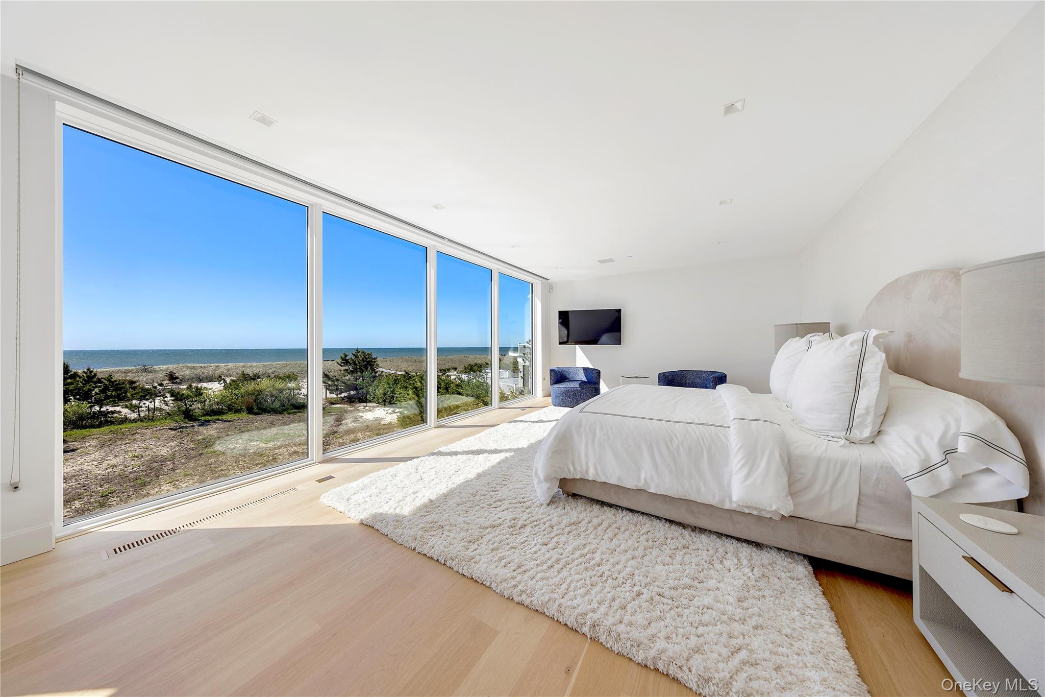 345 Dune Road Westhampton Beach, NY 11978 - Photo 17 of 34 a large white bed in a white room