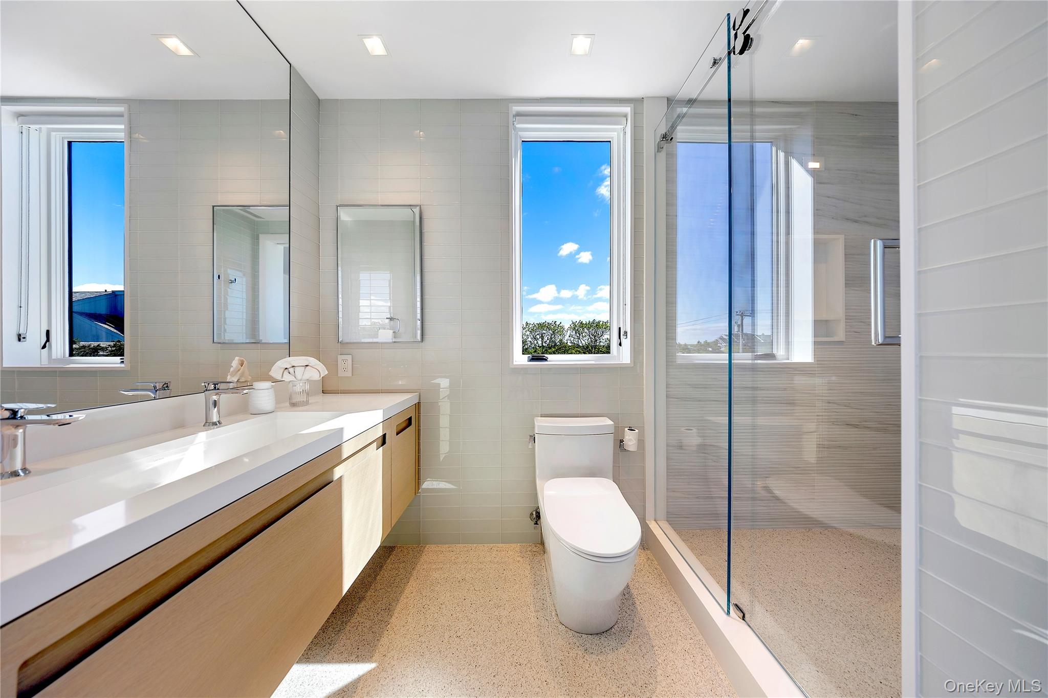 345 Dune Road Westhampton Beach, NY 11978 - Photo 20 of 34 a bathroom with a toilet a sink and a large mirror
