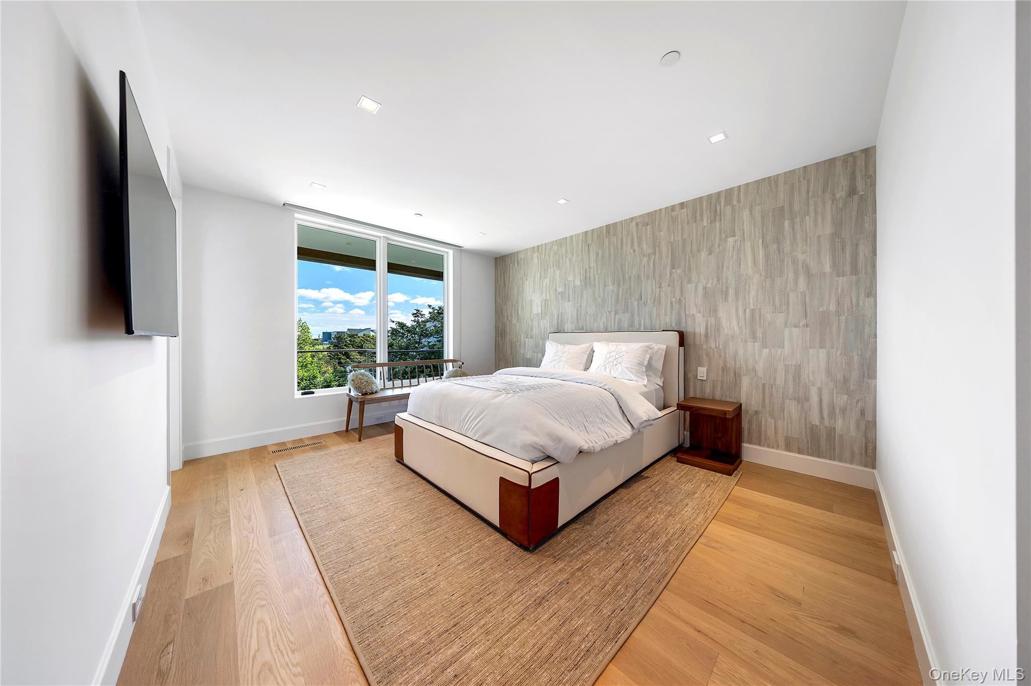 345 Dune Road Westhampton Beach, NY 11978 - Photo 23 of 34 a bed sitting in a spacious bedroom next to a window