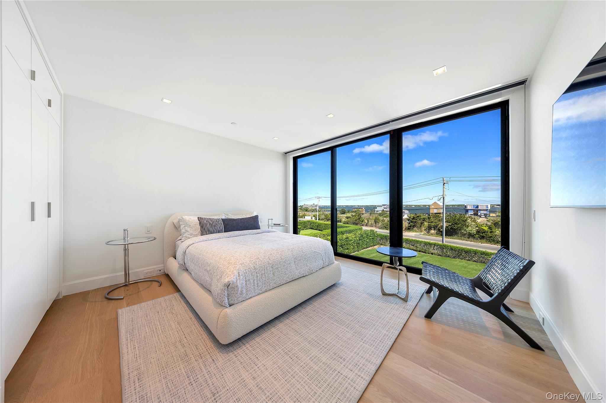 345 Dune Road Westhampton Beach, NY 11978 - Photo 26 of 34 a bedroom with a bed and a large window