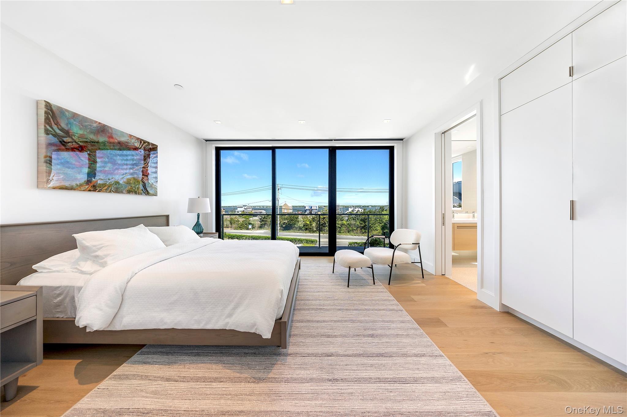 345 Dune Road Westhampton Beach, NY 11978 - Photo 28 of 34 a spacious bedroom with a large bed and a large window
