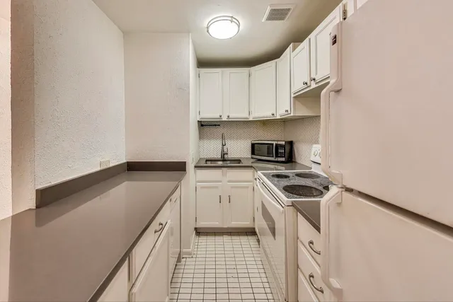 a kitchen with granite countertop a sink a stove and cabinets