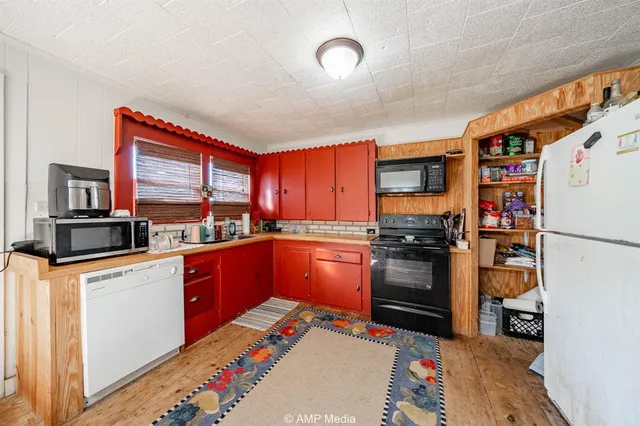 a view of a dining room with furniture and a kitchen