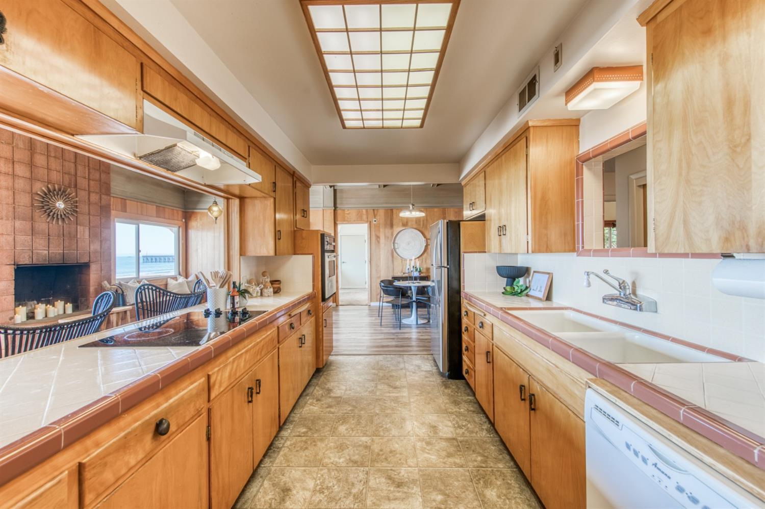 8 Ocean Front Lane Cayucos, CA 93430 - Photo 17 of 32 a large white kitchen with kitchen island a large window a sink and a couch
