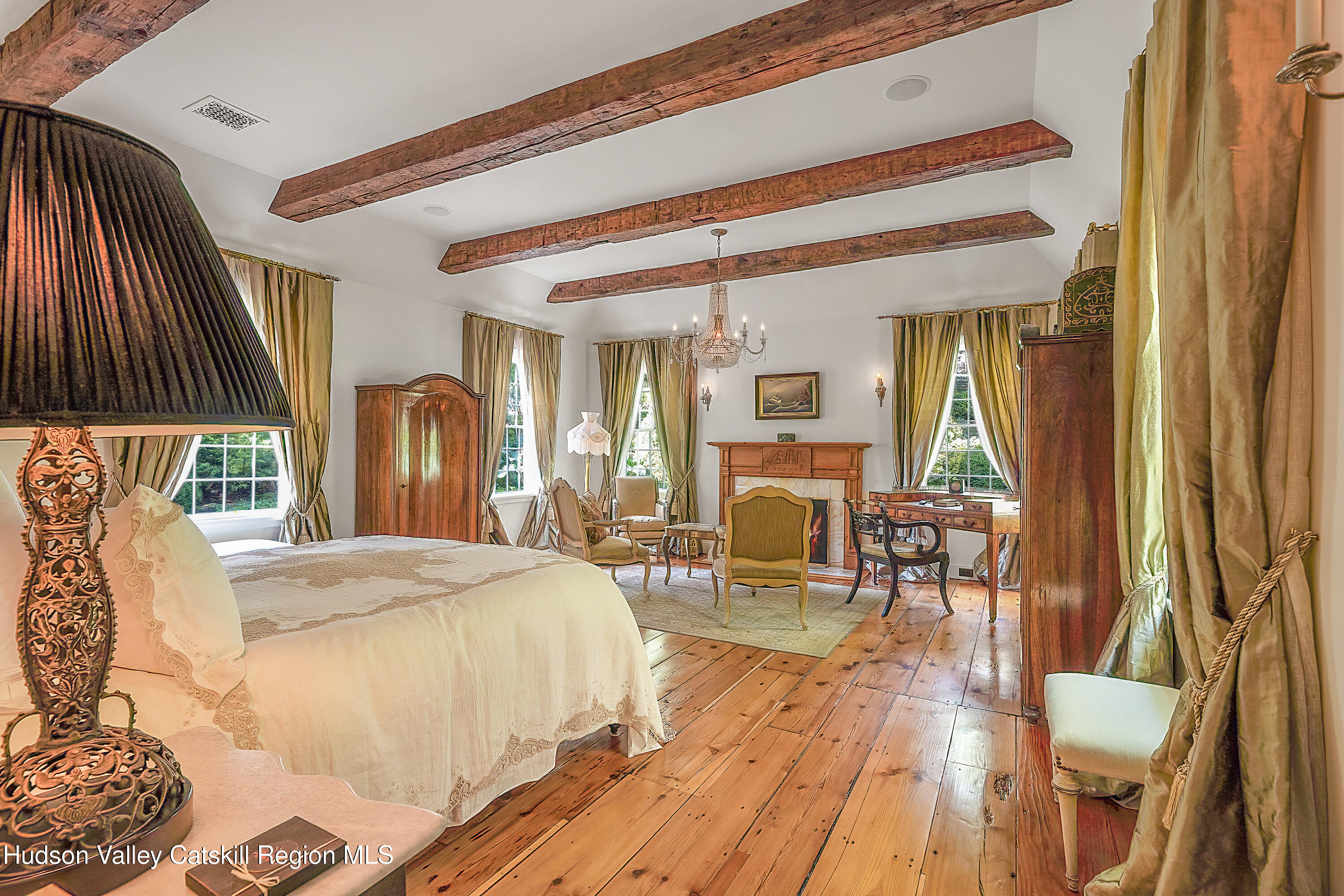 47 White Bridge Road Old Chatham, NY 12136 - Photo 17 of 68 a spacious bedroom with a bed a table and large mirror with wooden floor