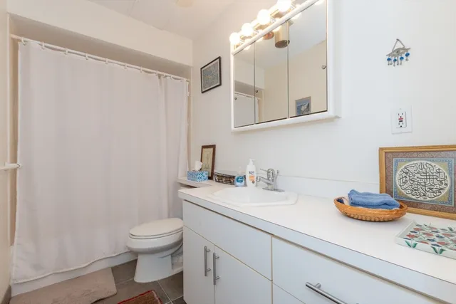 a bathroom with a granite countertop sink a toilet and a mirror