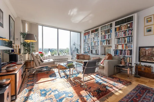 a living room with furniture a rug and a large window