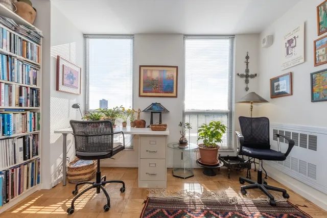 a living room with furniture a bookshelf and a window