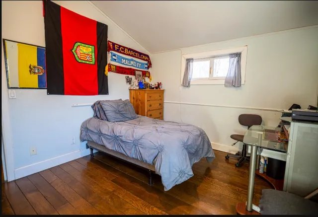 a bedroom with a bed and painting on the wall