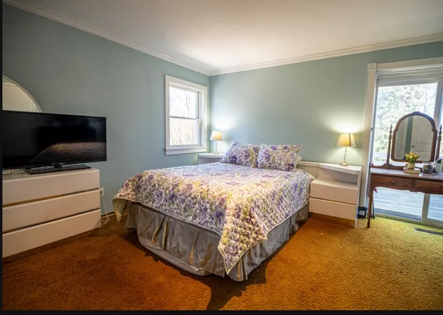 a bedroom with a bed and a flat screen tv