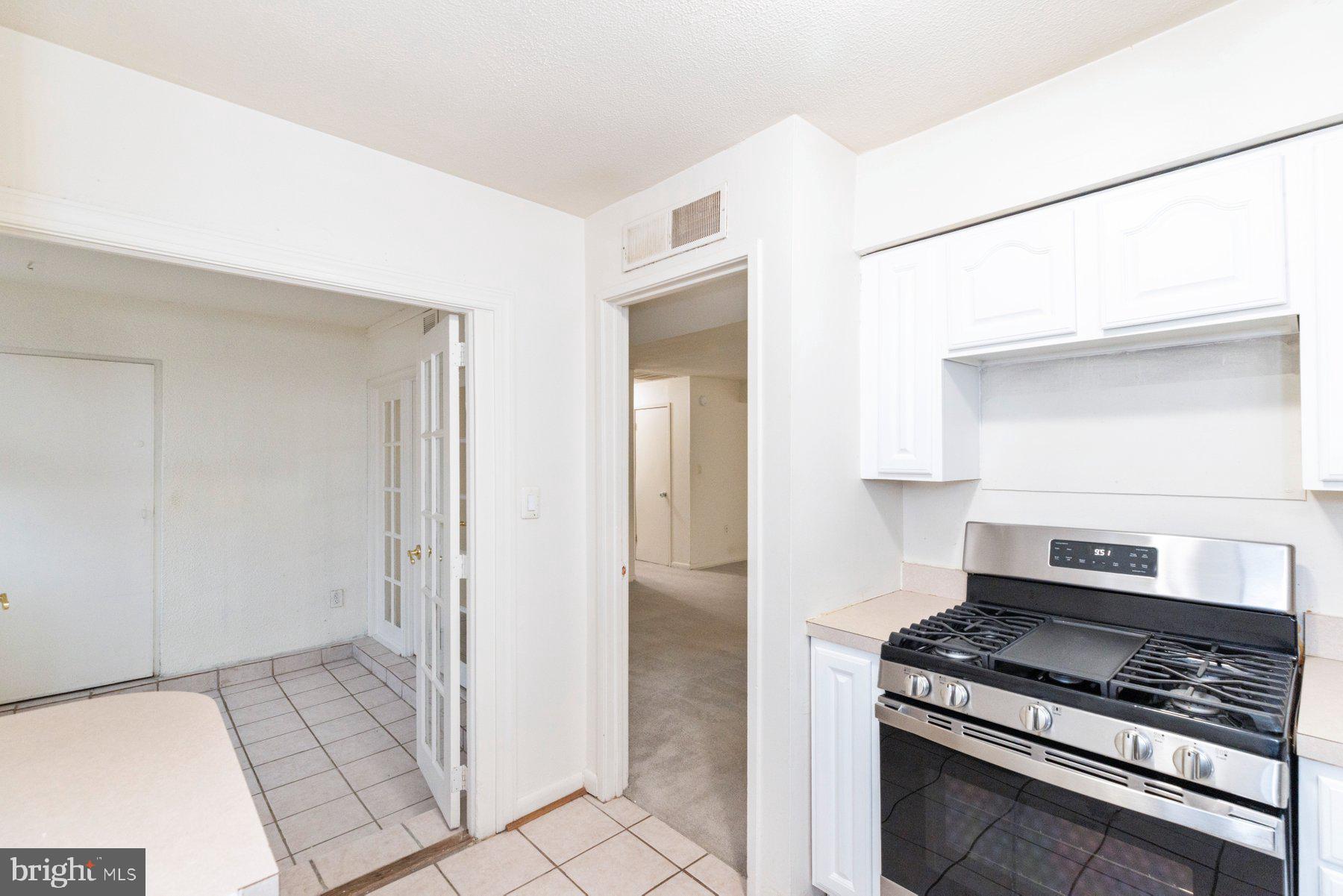 5866 Thunder Hill Road, Unit A4 Columbia, MD 21045 - Photo 4 of 20 a kitchen with white cabinets and a stove top oven