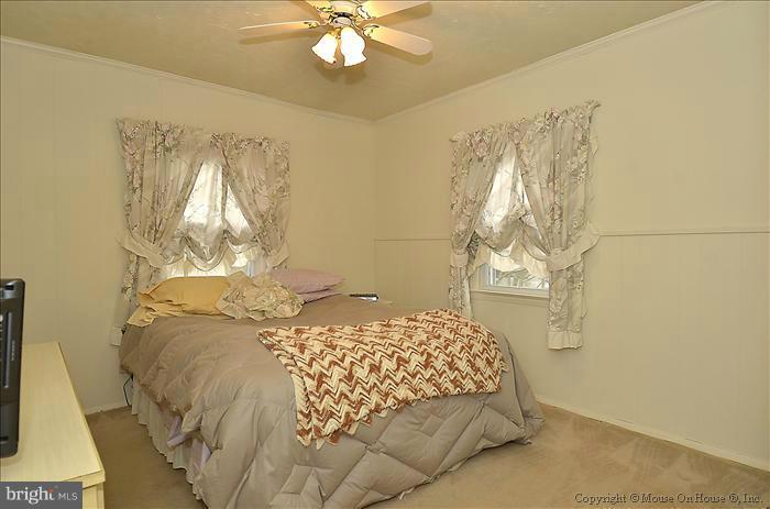 4219 Round Hill Road Silver Spring, MD 20906 - Photo 2 of 19 a bedroom with a bed and a chandelier