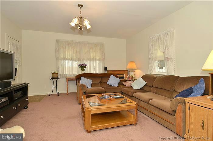 4219 Round Hill Road Silver Spring, MD 20906 - Photo 9 of 19 a living room with furniture a chandelier and a flat screen tv