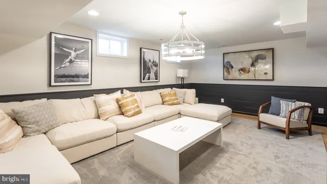 a living room with furniture chandelier and a window
