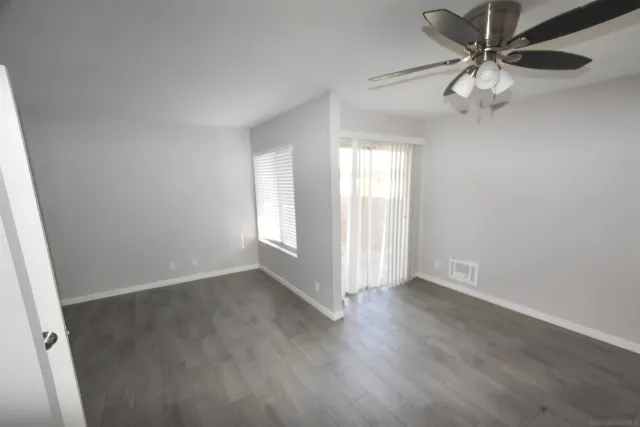 an empty room with windows and fan