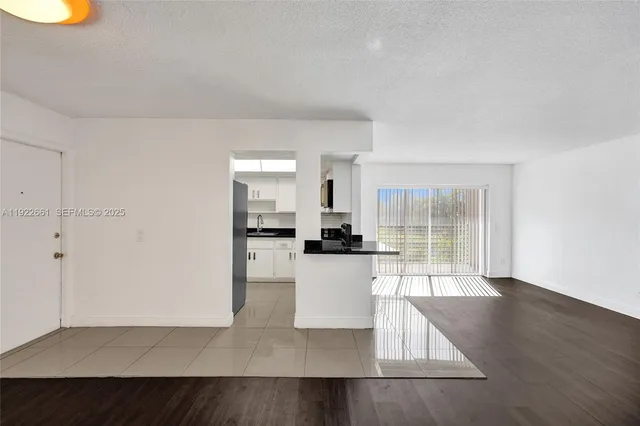 a view of a kitchen with a sink and a refrigerator