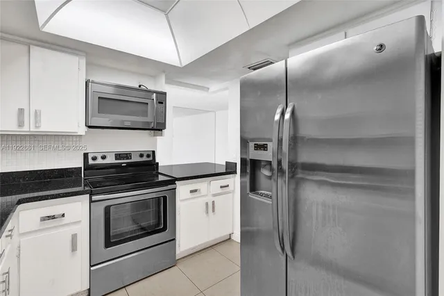 a kitchen with granite countertop white cabinets and a sink