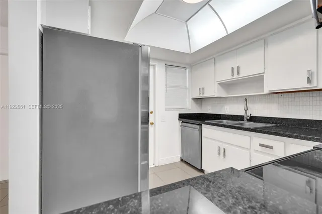 a bathroom with a granite countertop toilet a sink and a mirror