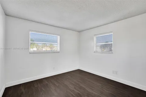 an empty room with wooden floor and sliding door
