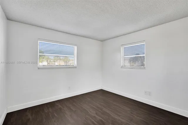 an empty room with wooden floor and sliding door