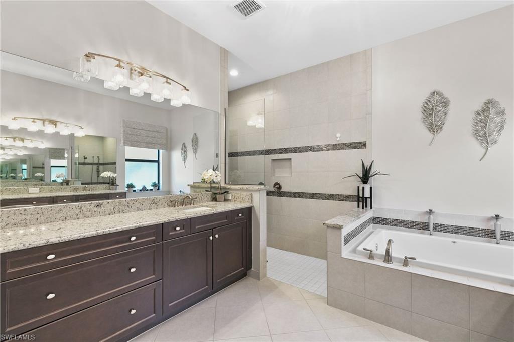4370 Caldera Circle Naples, FL 34119 - Photo 15 of 35 a bathroom with a granite countertop bathtub sink and mirror