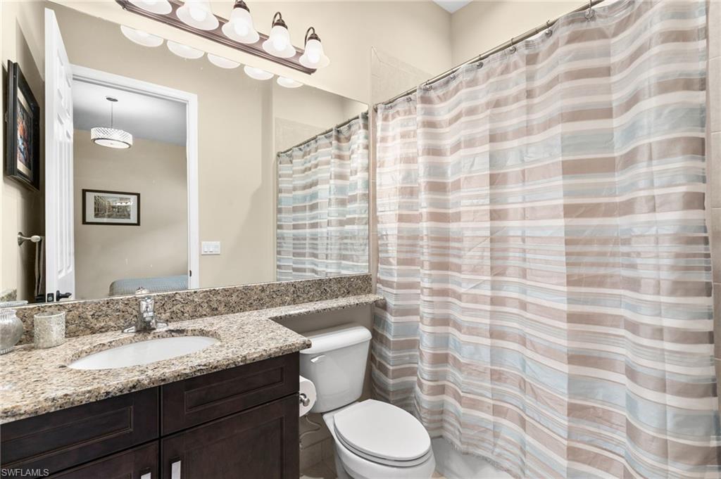 4370 Caldera Circle Naples, FL 34119 - Photo 18 of 35 a bathroom with a granite countertop bathtub sink vanity mirror and toilet