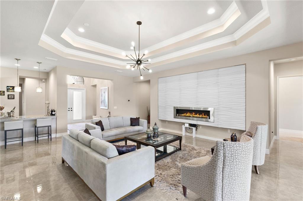 4370 Caldera Circle Naples, FL 34119 - Photo 3 of 35 a living room with furniture and a chandelier